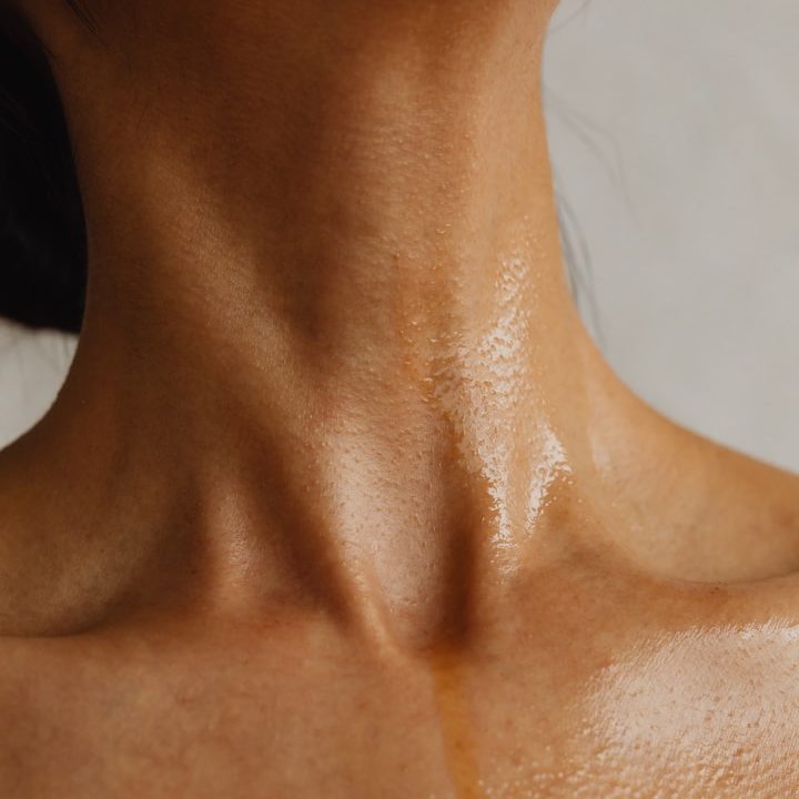 Haut- und Scleimhautprobleme Nackte, leicht gebräunte und glänzende Haut am unteren Halsbereich.