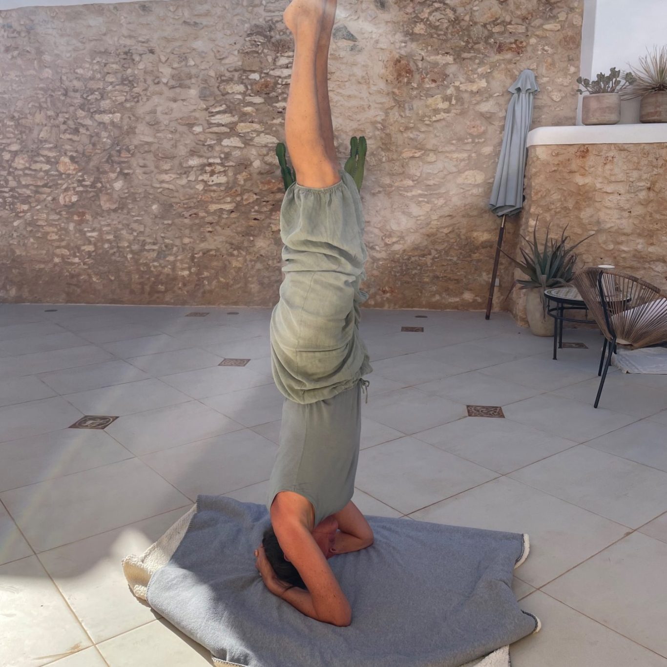 Herz über Kopf Meike Völkner macht in Sommerkleidung einen geraden Kopfstand.